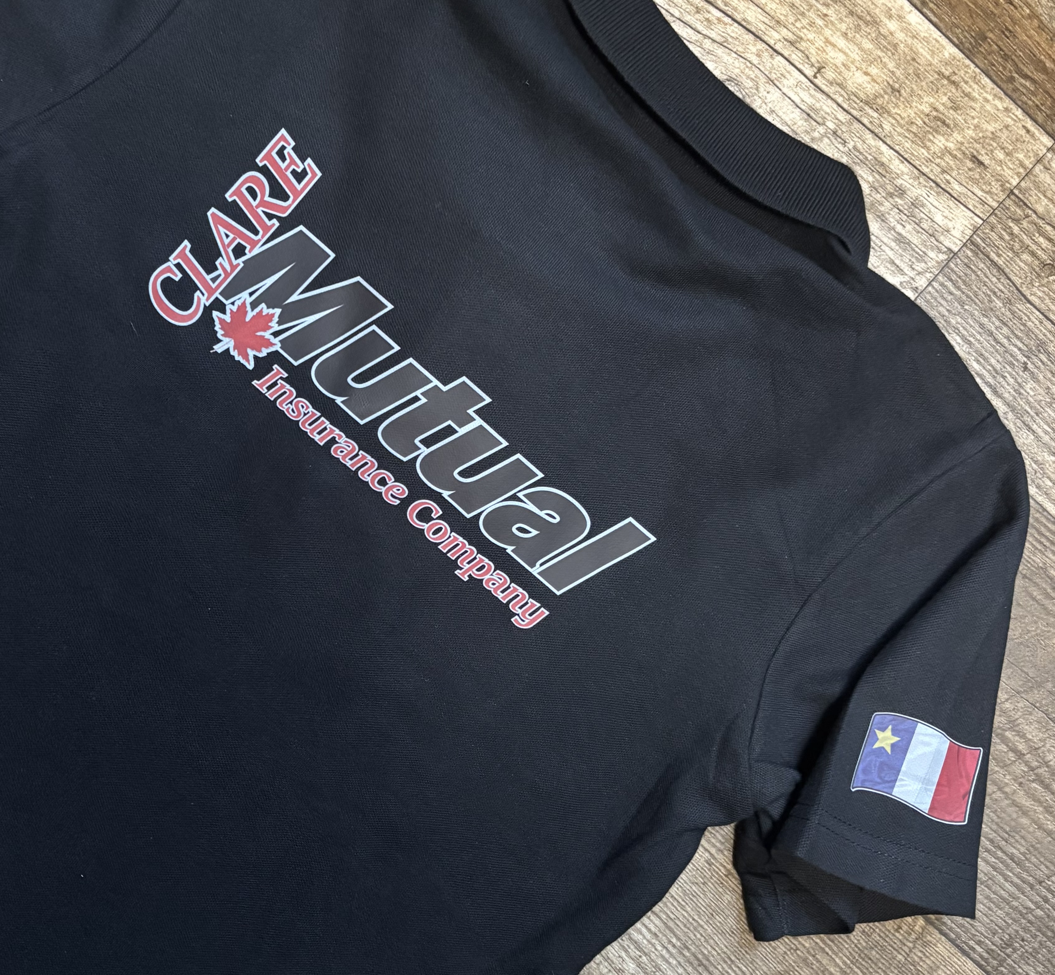 Clare Mutual Insurance shirt — back print with Acadian flag sleeve